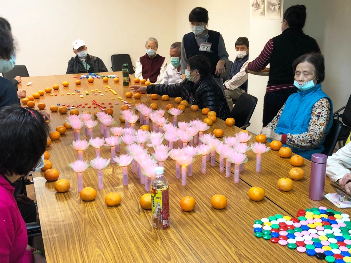 長輩們還以蓮花燈排出吉祥字樣，最後用橘子排出兩顆愛心把平安與吉祥包圍起來，與社區據點活動主軸「戀（練、鏈）幸福」串連起來。