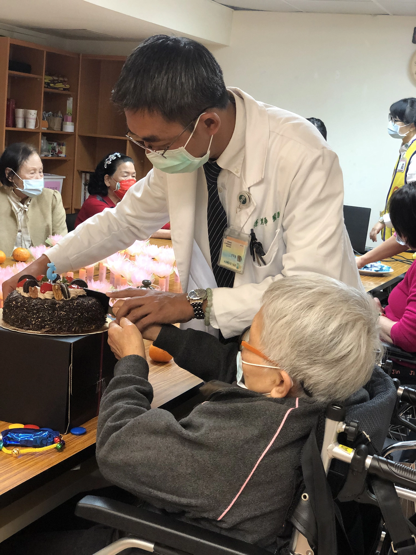 傅進華醫師與長輩一起切蛋糕，歡慶失智據點邁入第五年。