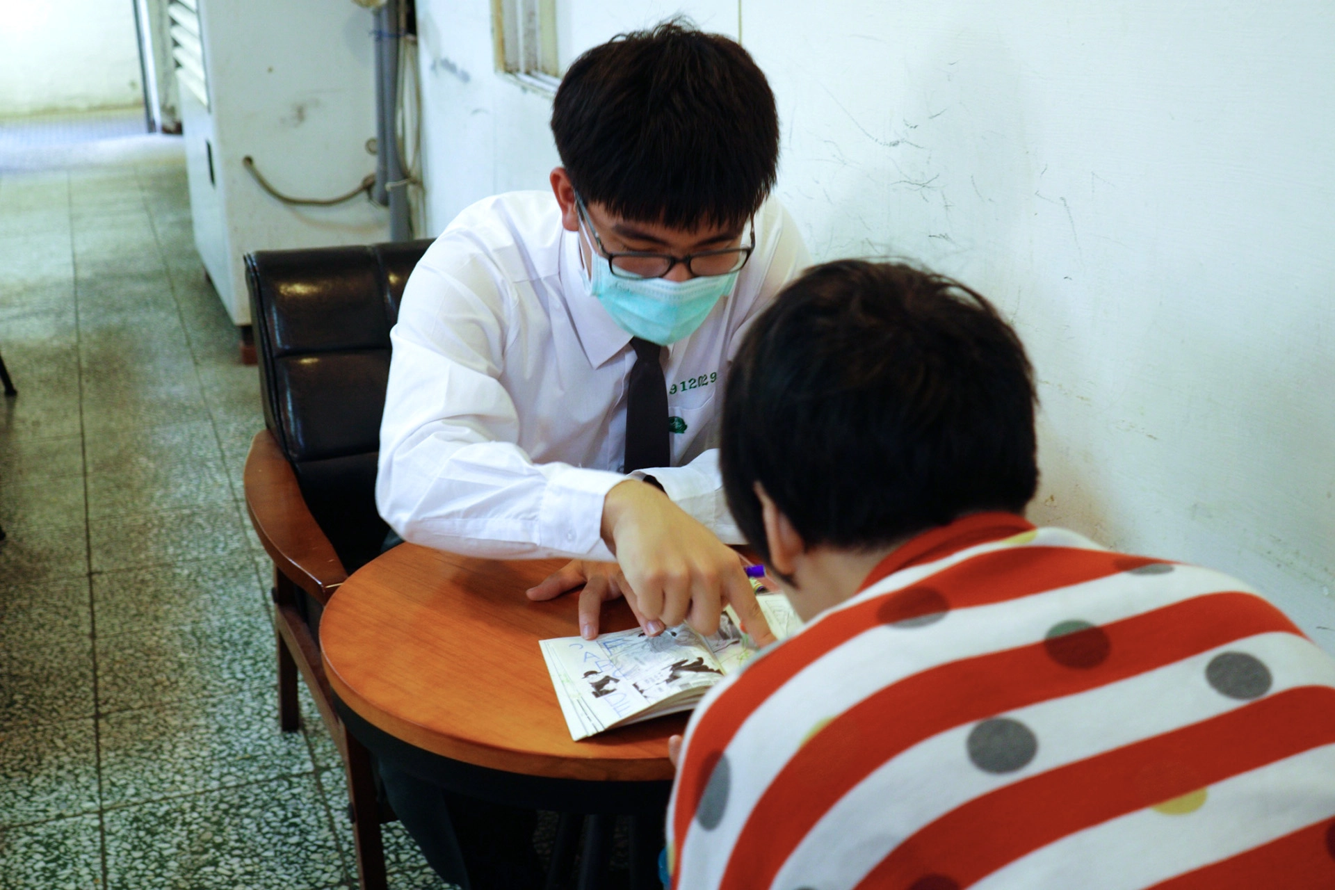 鄭新霖同學陪著院生閱讀漫畫書。