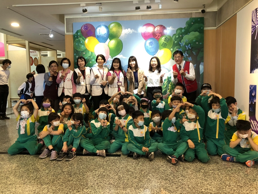 教育部鄭文瑤專門委員與展場志工及參展小學生合影。