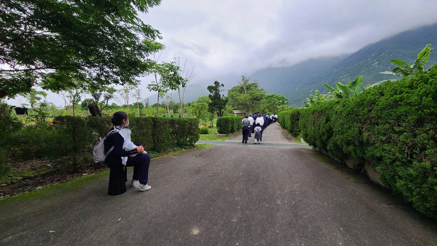 圖說：朝山儀式開始，但媽媽懷中的兩歲小孩還在沉睡，媽媽只能抱著女兒望著朝山隊伍緩慢前進。(圖:林永森攝)