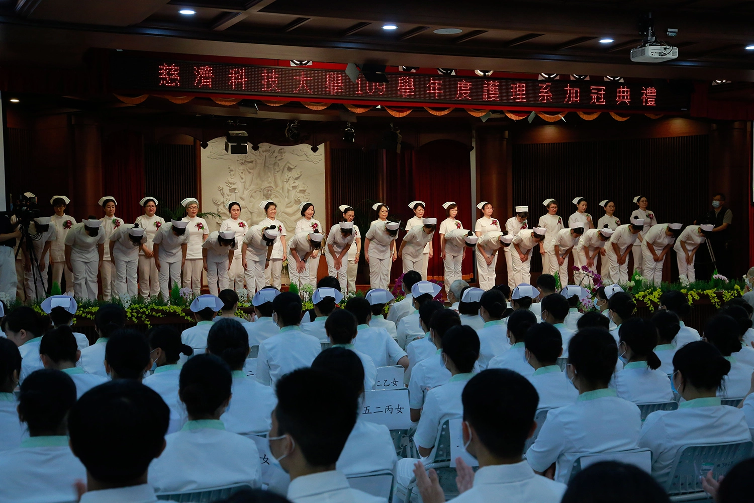 學生轉身向師長鞠躬，見證踏入護理生涯的里程碑。