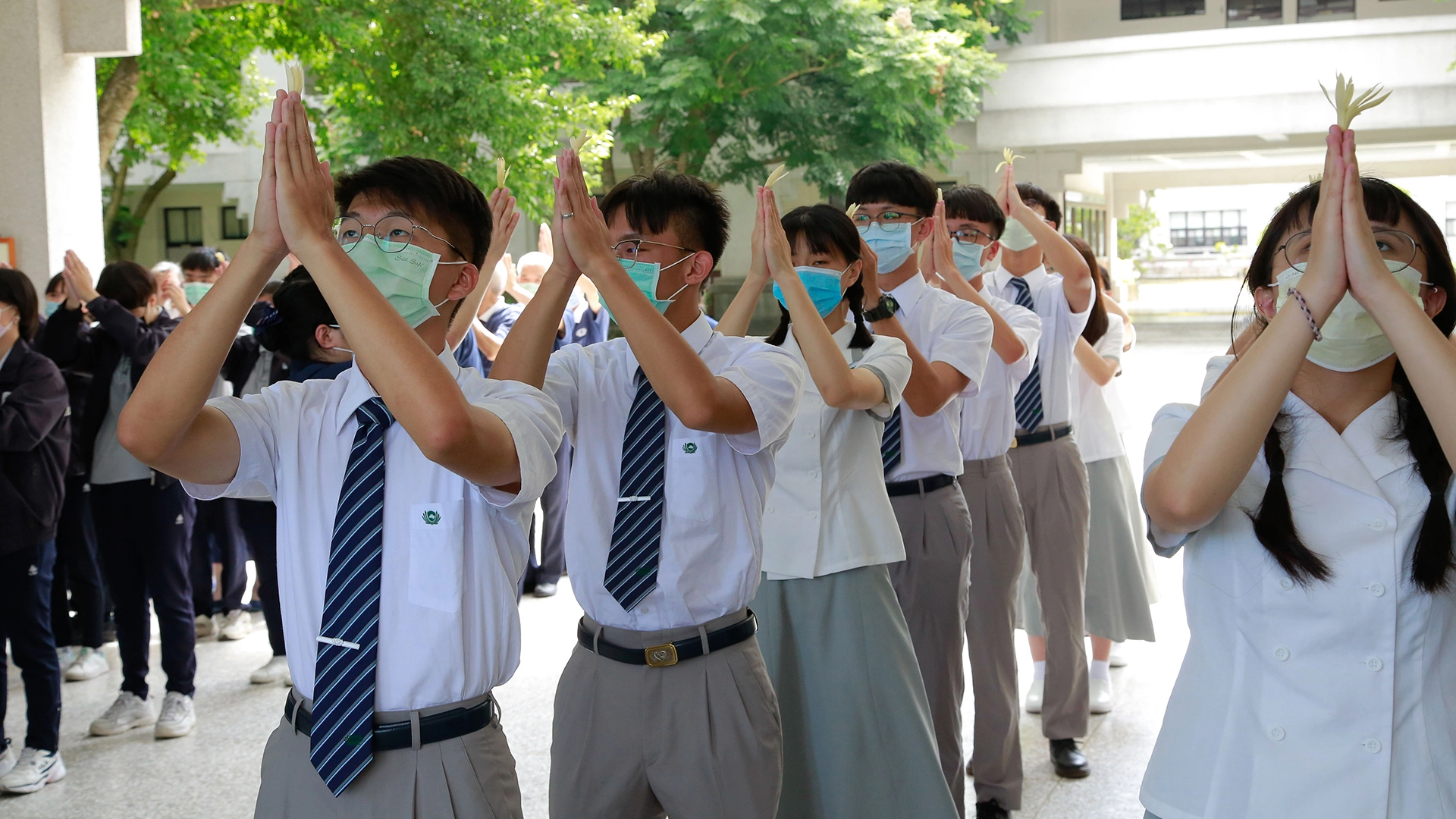 眾人雙手合十、虔誠祈禱、凝聚心念，關心全球疫情。