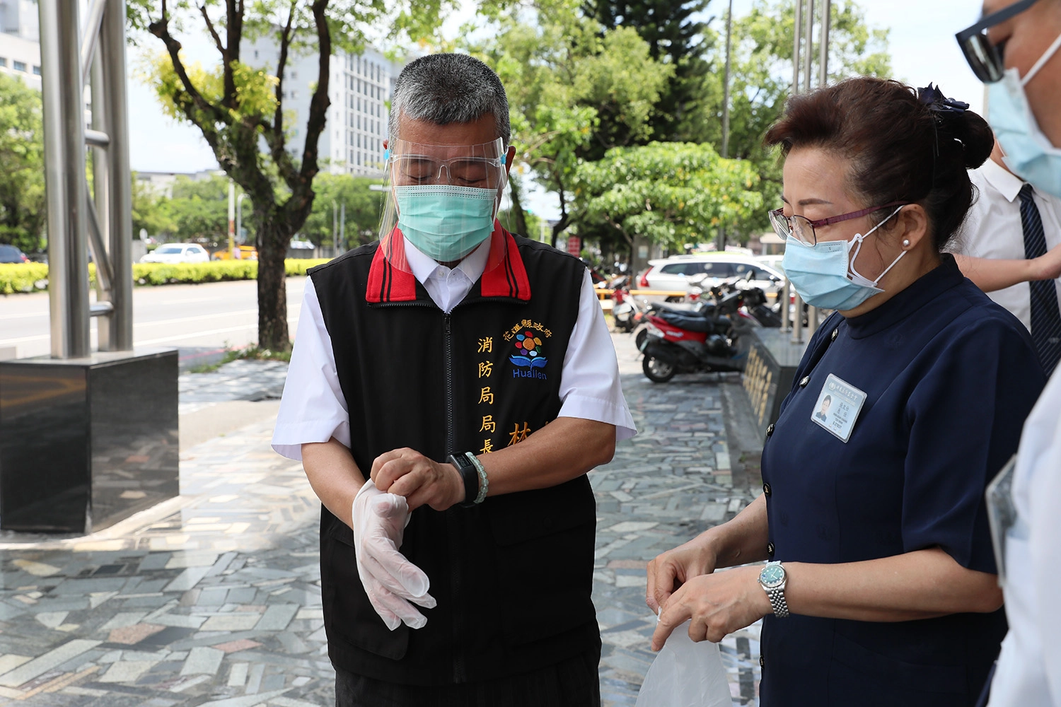 花蓮慈濟志工5月28日前往花蓮縣消防局捐贈防護面罩、PVC手套，由局長試戴確認是否合用。