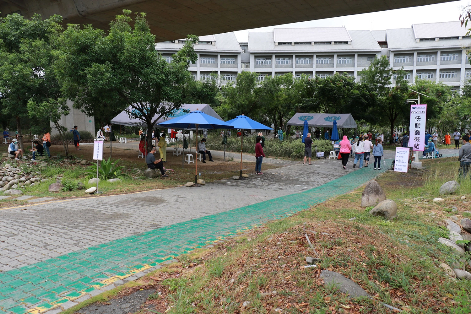 週日上午陣雨降臨，仍有大批民眾來到臺中慈院快篩站篩檢。
