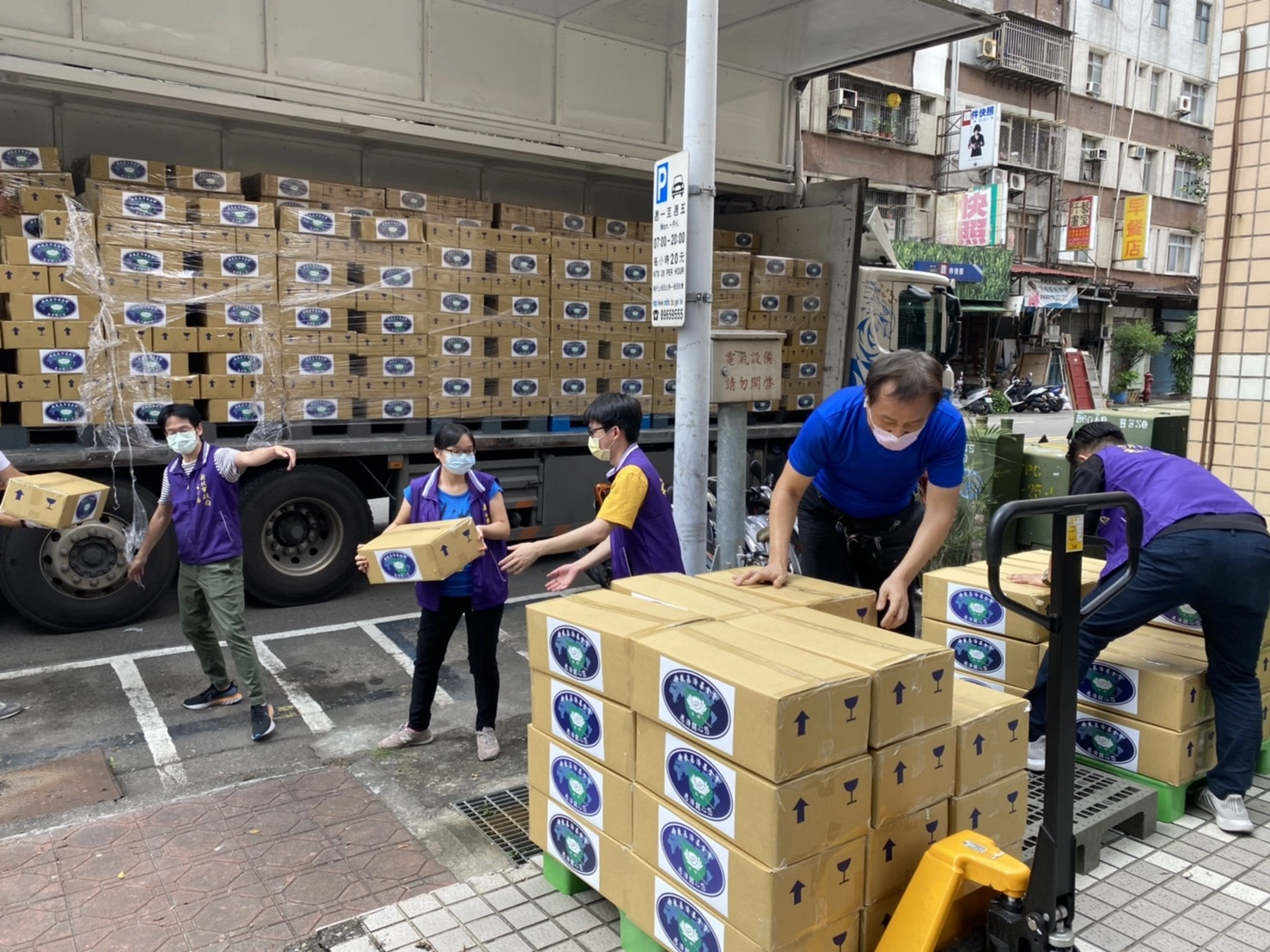 慈濟基金會利用大型運輸車載運食物箱到新北市三重社福中心。