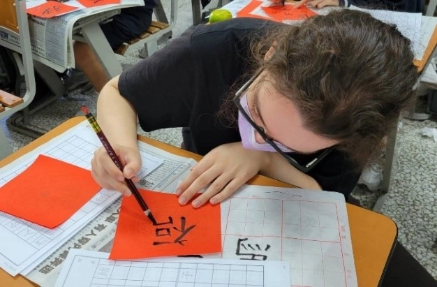 臺南慈中高中部學生指導來自英國成大外籍學生Lauren寫書法，新鮮很有趣。