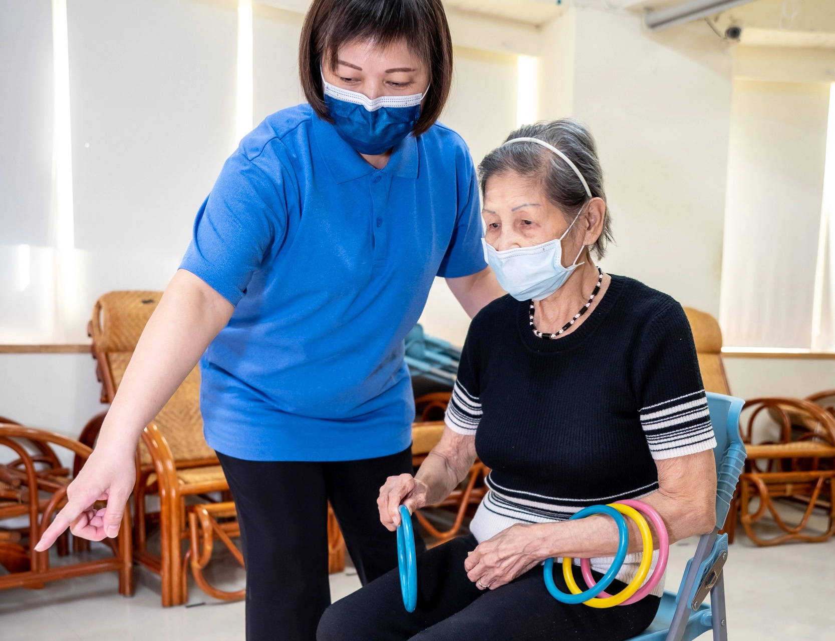 金枝奶奶在照服員的引導下參與活動，在遊戲中練習加強手眼協調、認知等功能。