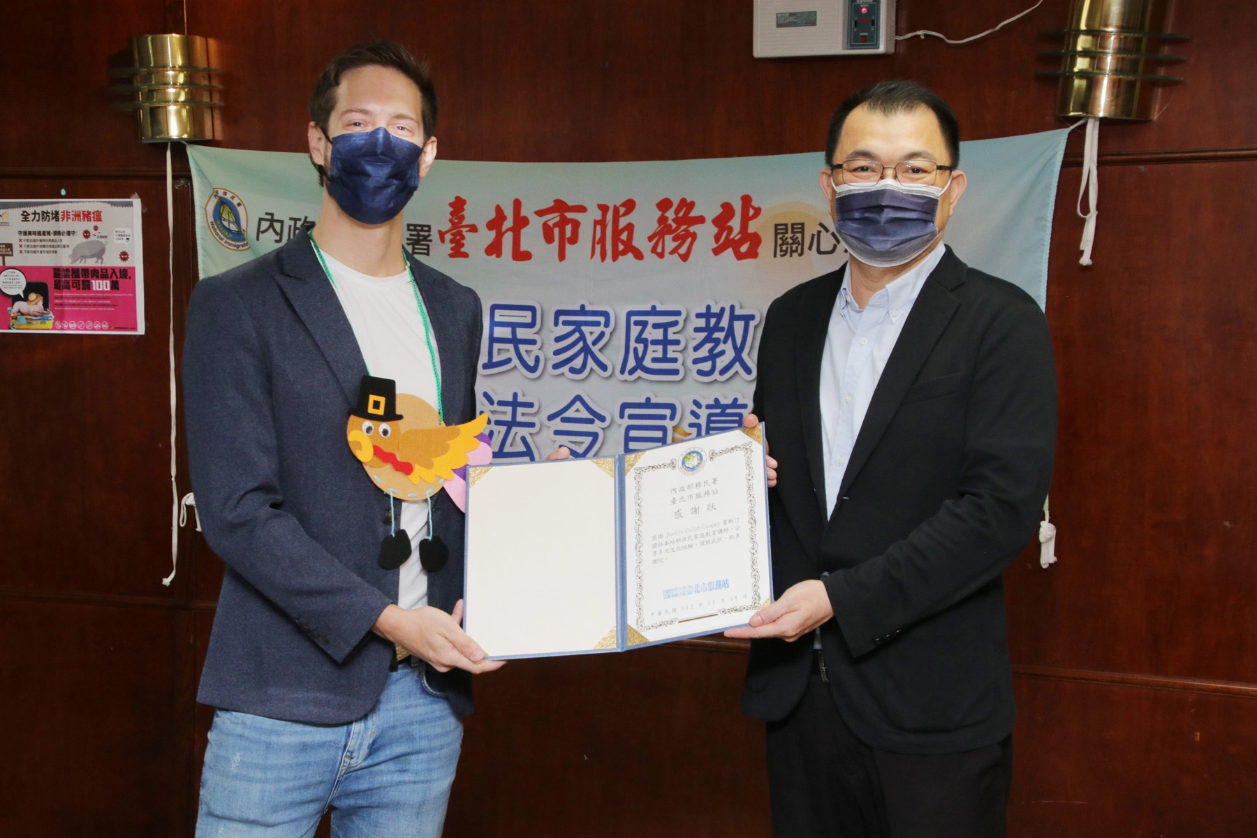 移民署北區事務大隊臺北市服務站特贈感謝狀，給擔任新住民家庭教育講師的賈斯汀（左），謝謝他分享多元文化經驗。左為臺北市服務站視察鄭宗仁。