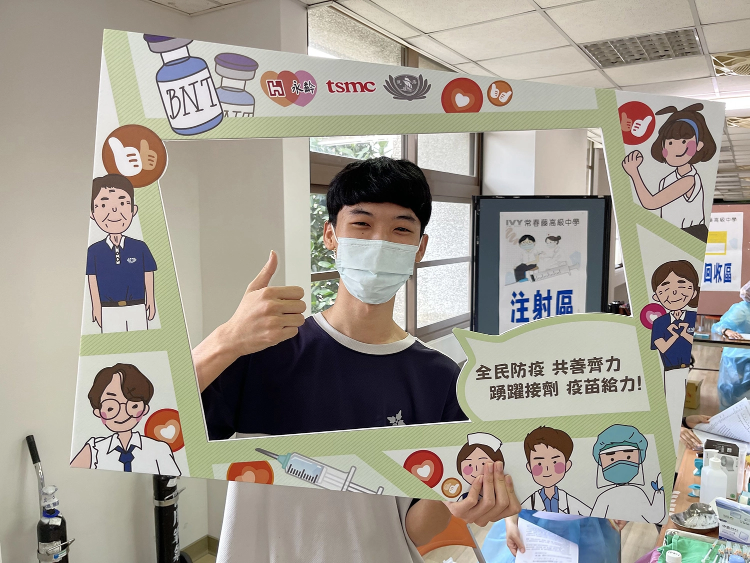 同學打完疫苗，開心拿打卡板比讚拍照留念。