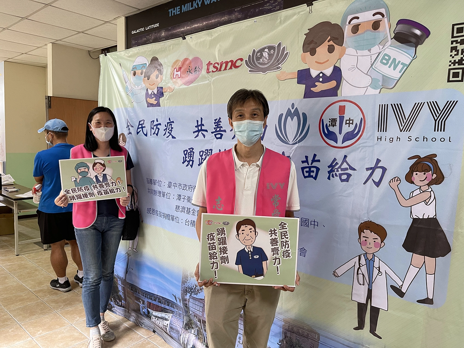 常春藤中學家長會長陳嘉輝（右）與徐碧琴（左）夫妻二人到校擔任志工，特地到場關心並感謝醫護人員付出，並在打卡牆前舉手牌合影。