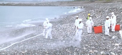 環保局應變人員岸際沖洗油污