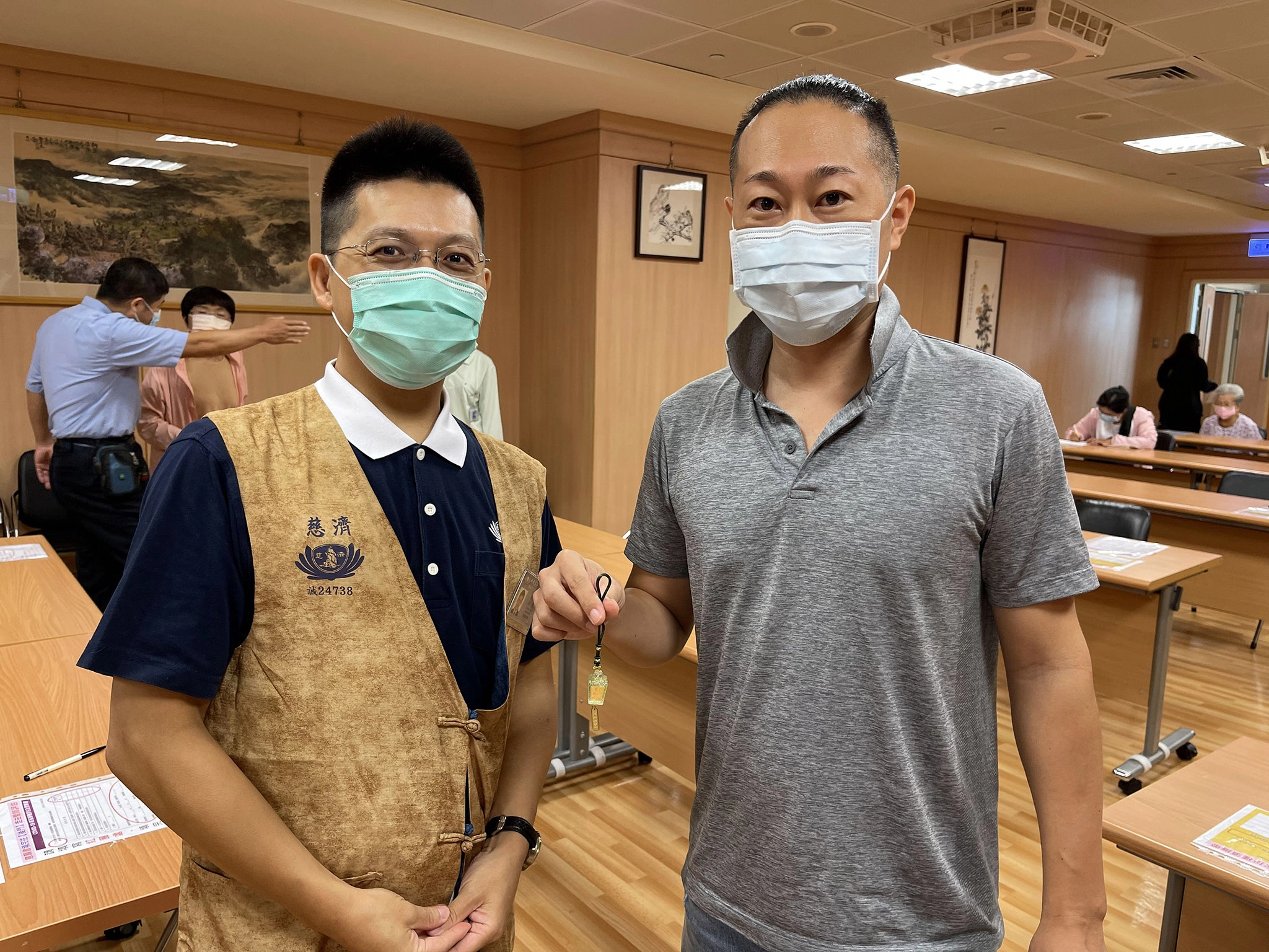 市川先生（右）獲贈靜思祈福心燈吊飾，特地與日語志工劉奕男師兄（左）合影。