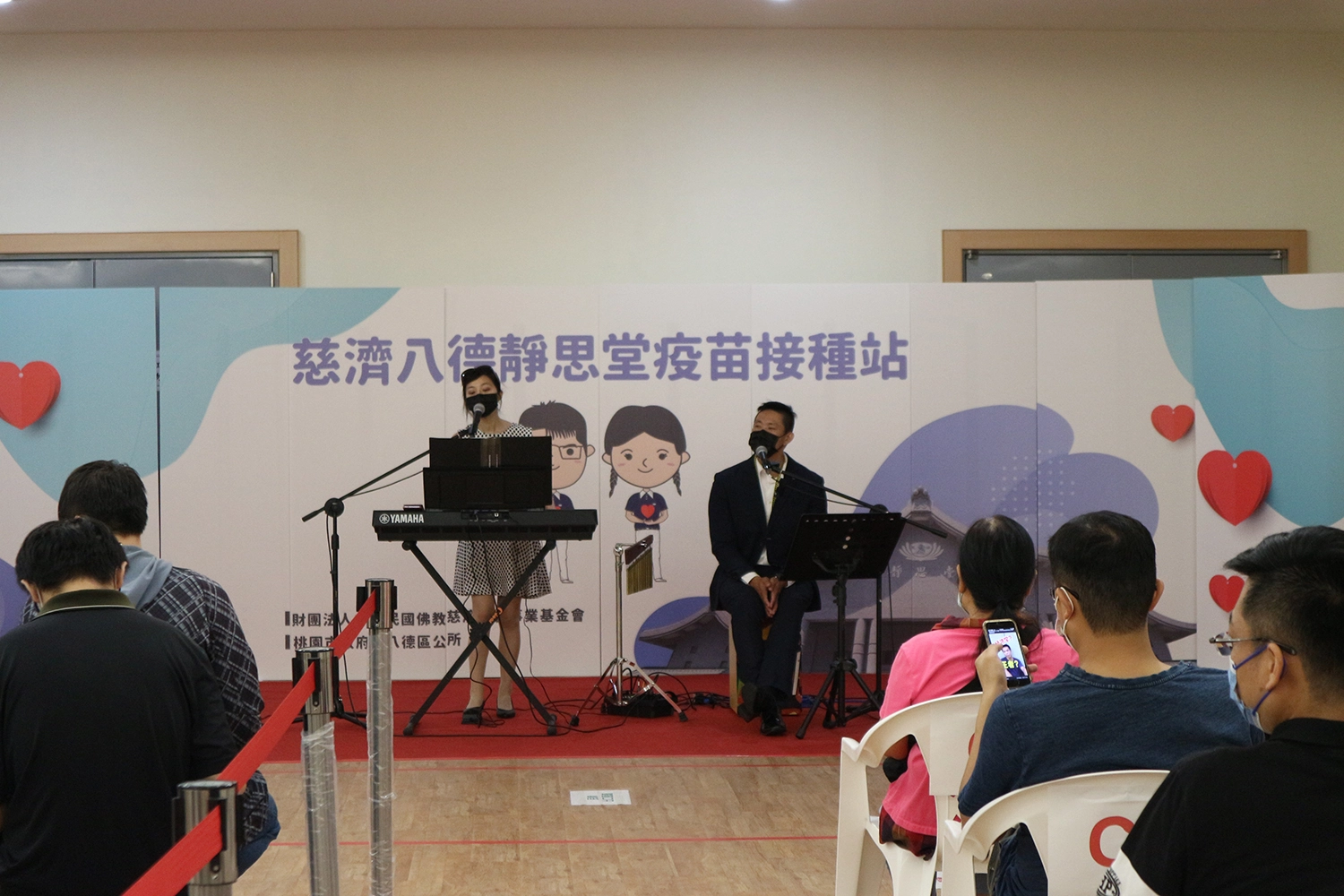 八德靜思堂，今(14號)日進行BNT疫苗第一劑施打，邀請來自北投的「青梅竹馬」(團體名)帶來電子琴彈唱，透過輕快的演唱，讓鄉親能放鬆心情接種疫苗。