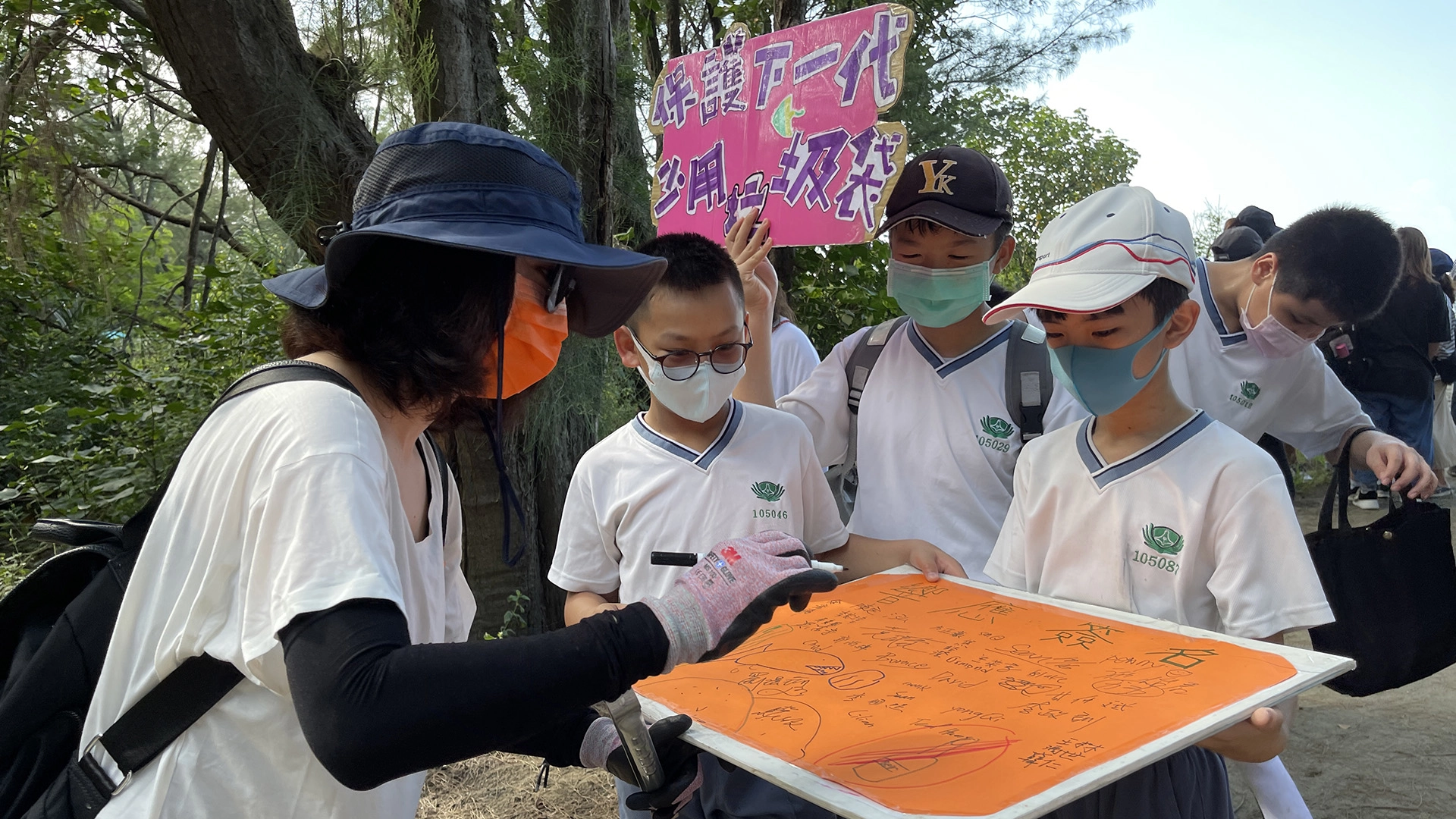跟沙灘遊客進行減塑宣導，遊客聽得專心