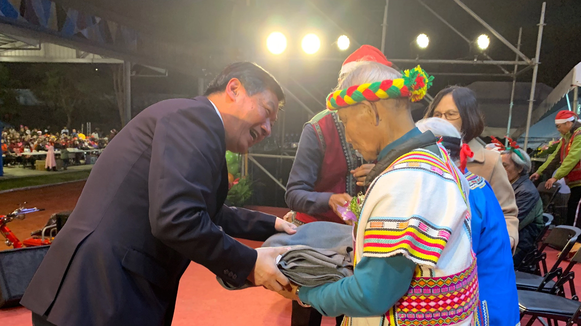  長年參與部落活動，慈發處主任呂芳川，在聖誕晚會上，為結婚五十年以上的長者夫婦送上環保毛毯與祝福。