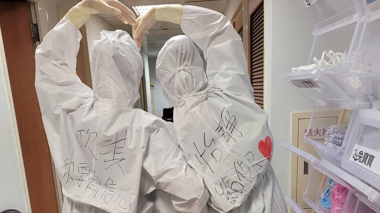 護理師們在隔離衣上畫上愛心，寫下祝福與鼓勵。