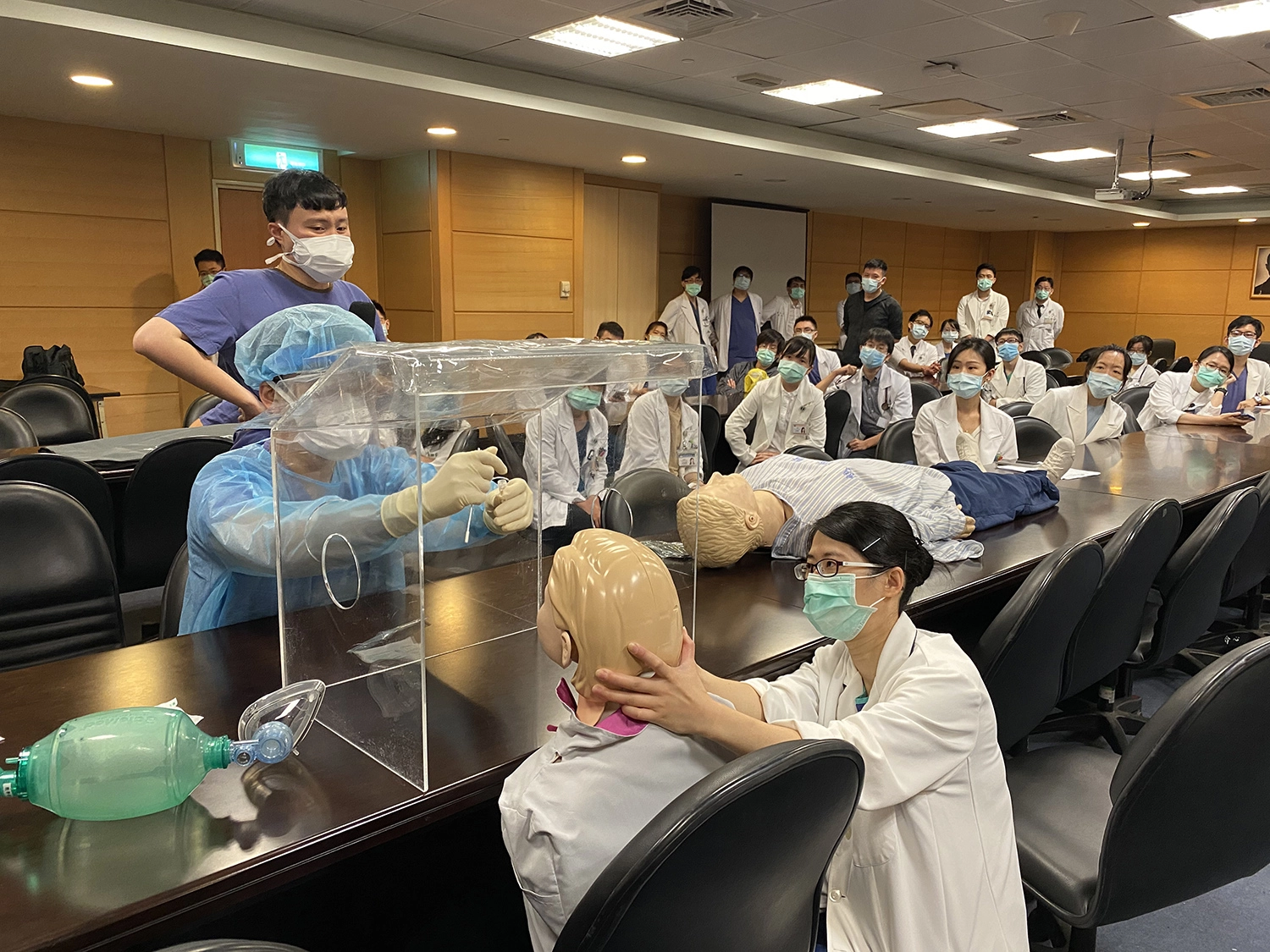 COVID-19疫情進入社區感染，疑似的、可能的病人如潮水般湧入，病人須經過評估及篩檢，才能進入診間(左)；為因應大幅提升的採檢需求，由急診醫護示範標準採檢流程，讓各專科醫師能支援採檢。（左圖/楊久滕；右圖/范宇宏）