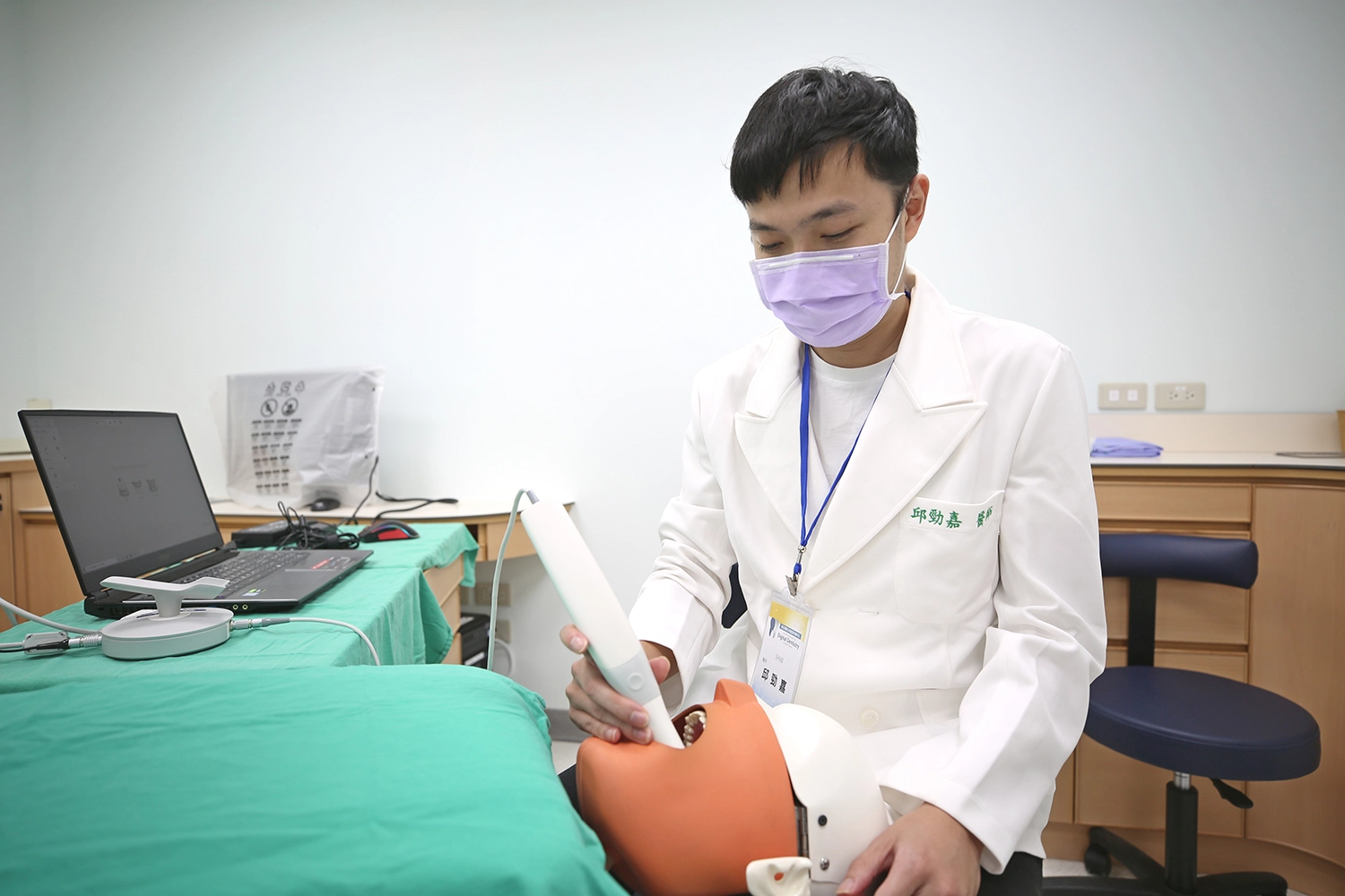 邱勁嘉牙醫師示範操作口掃機。