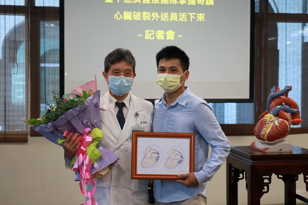 謝世榮主任（左）送鍾先生手繪心臟術前、術後的彩圖。