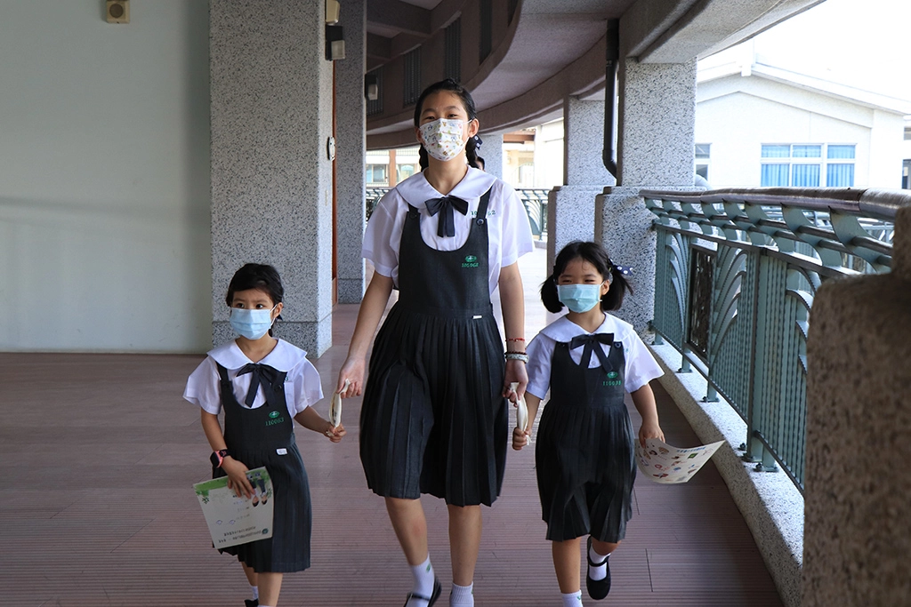 六年級學姊用手帕牽起兩位學妹的手認識校園。