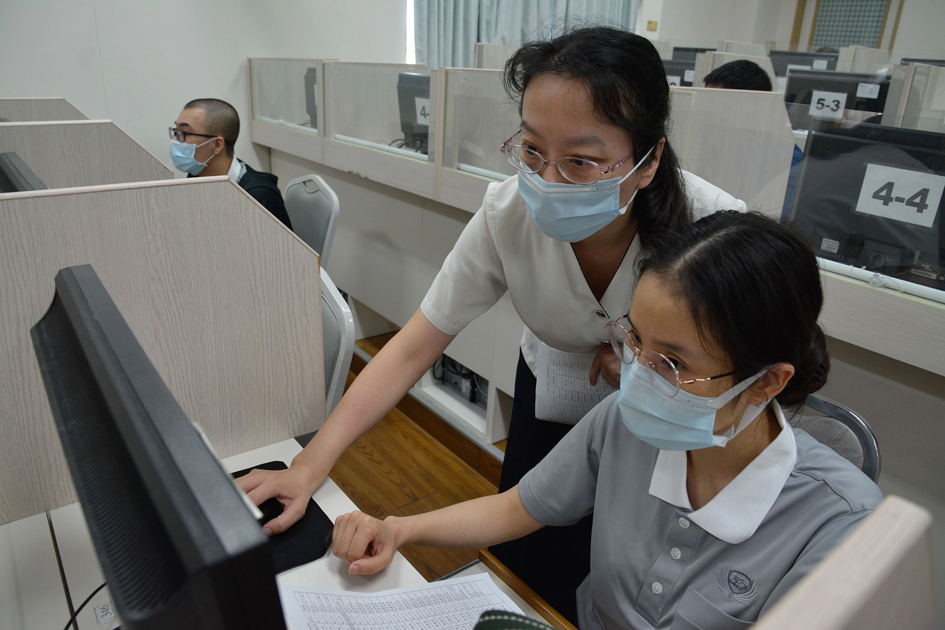 慈科大教職員協助學生在電腦教室選課。