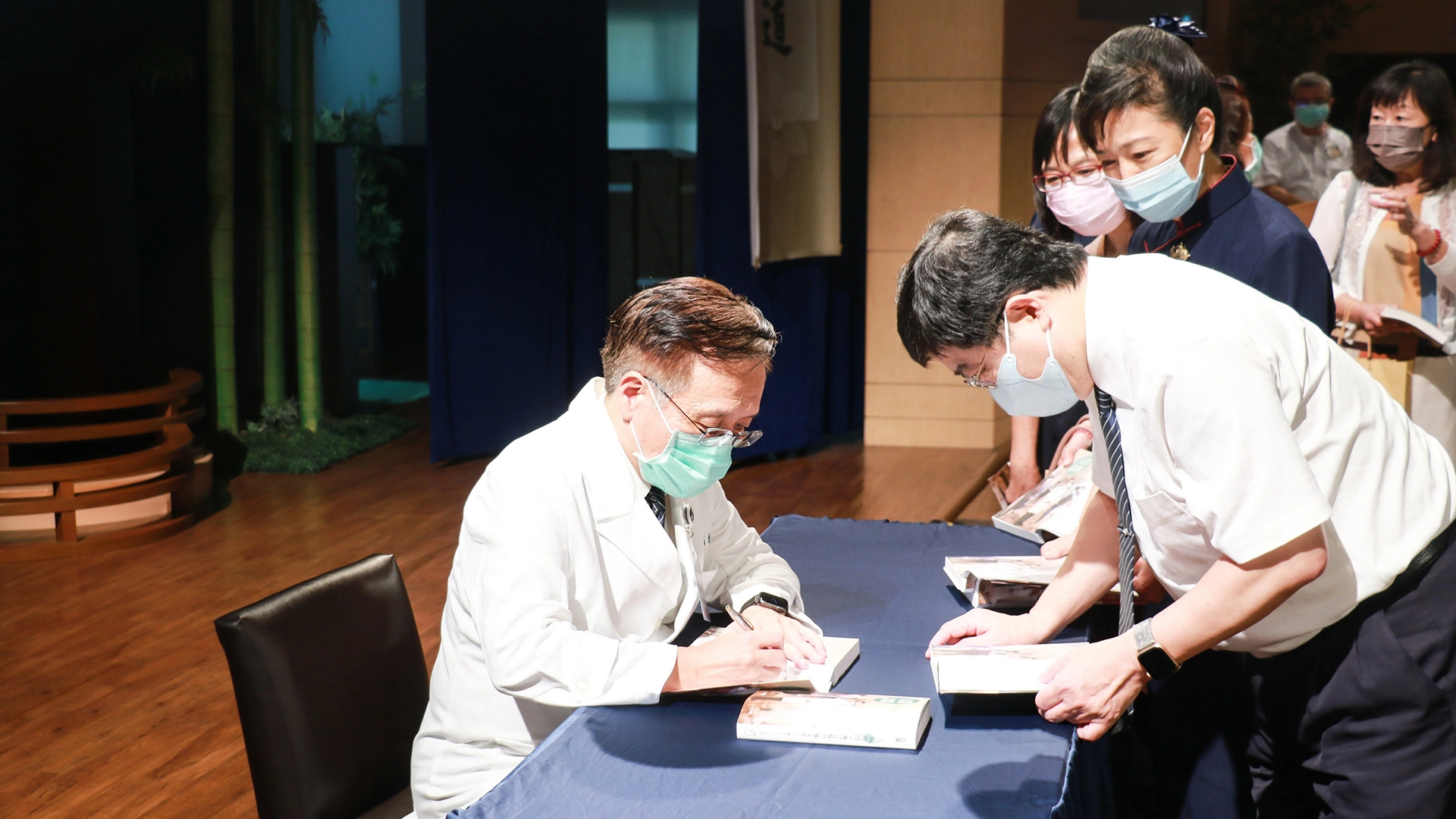 大林慈濟醫院副院長林名男（右）請簡守信院長在新書上留下簽名。