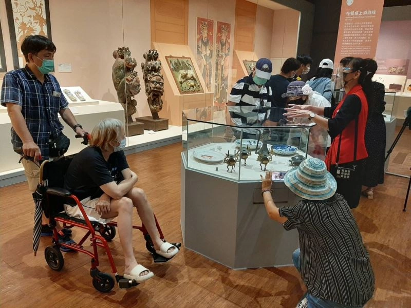民眾專心聆聽導覽員介紹在飲食器皿中會出現的傳藝動物及當中的涵義。