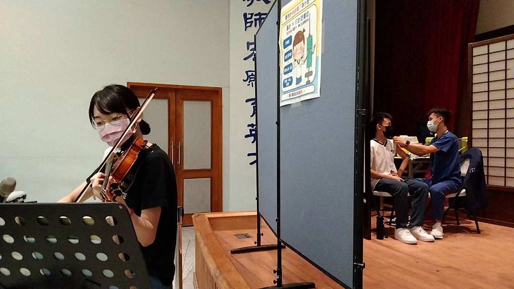 為了緩和施打的緊張心理壓力，校方在施打區安排小提琴演奏。