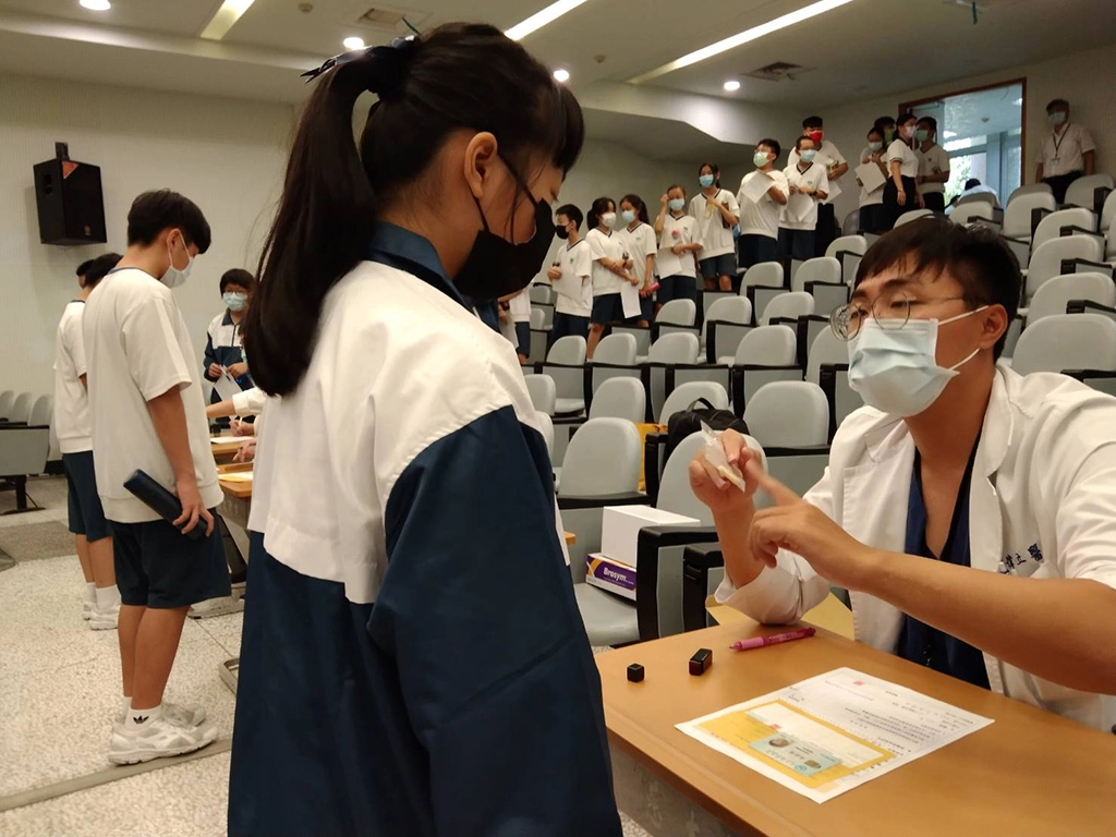 在階梯式的大禮堂座位區分層做出排隊、報到、問診等空間，學子們井然有序完成前置流程。