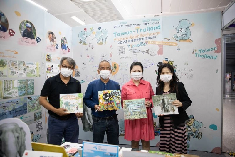 PUBAT主席Thipsuda_Sinchawarnwat（右二）、文化部駐泰國文化組長田又安（右一）與泰國繪本作家奇玩（左二）、皮達（左一）在臺灣繪本展位向觀眾介紹本次臺泰共創作品。