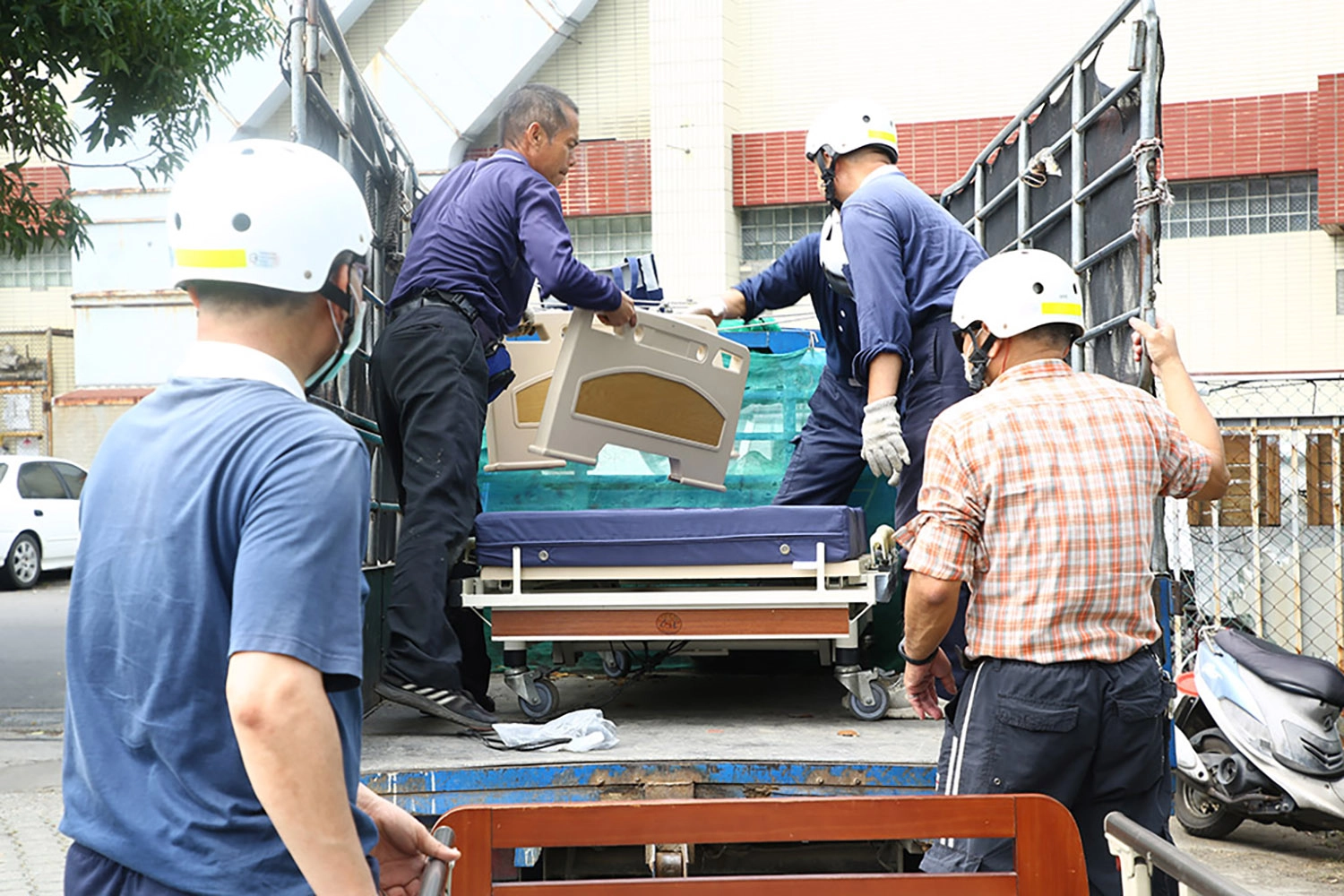 慈濟輔具平台志工將輔具搬運上車載運情形。