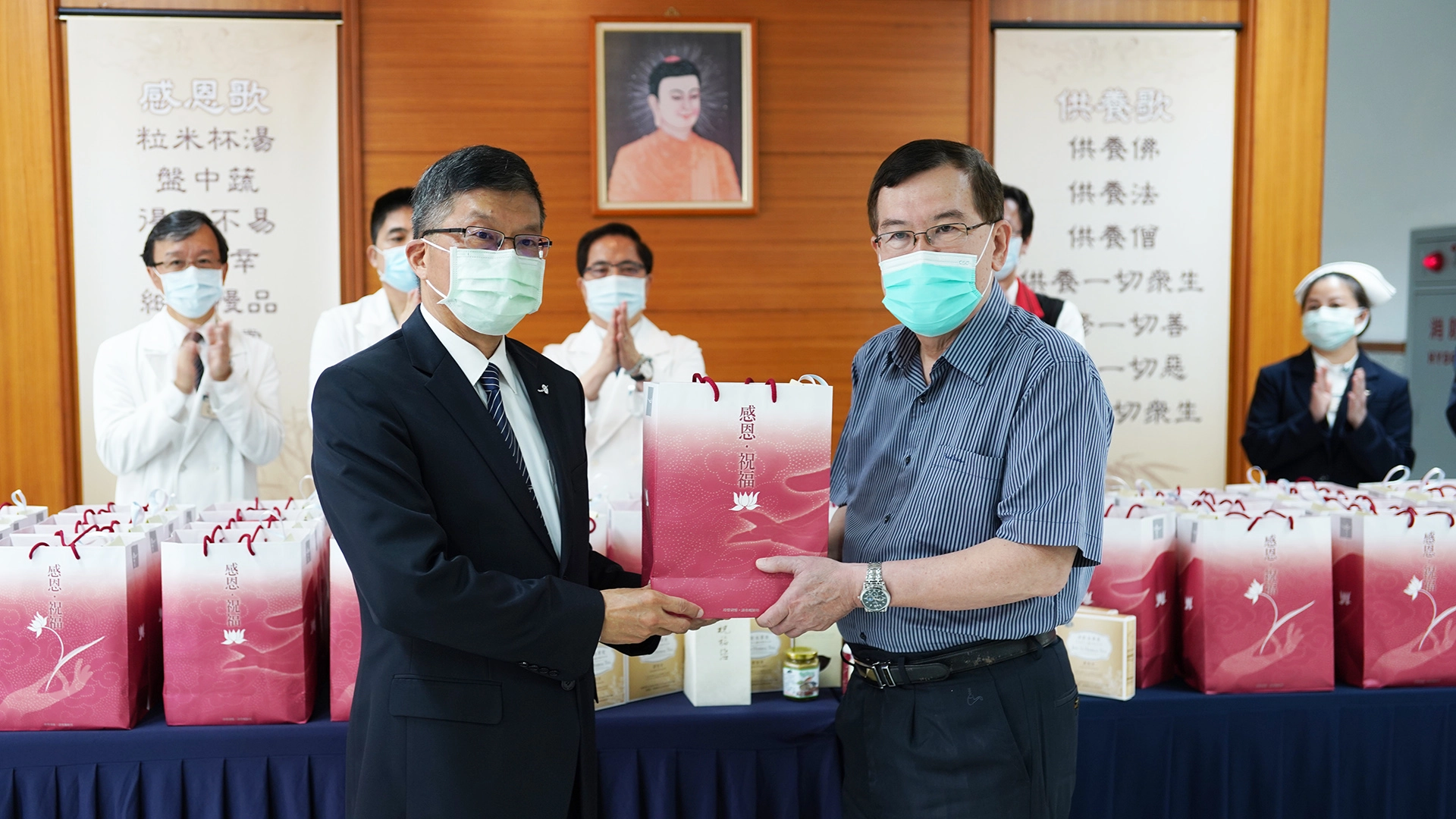 致贈儀式，由慈濟基金會副執行長劉效成(左)與加強型防疫旅館經理林于凱代表。