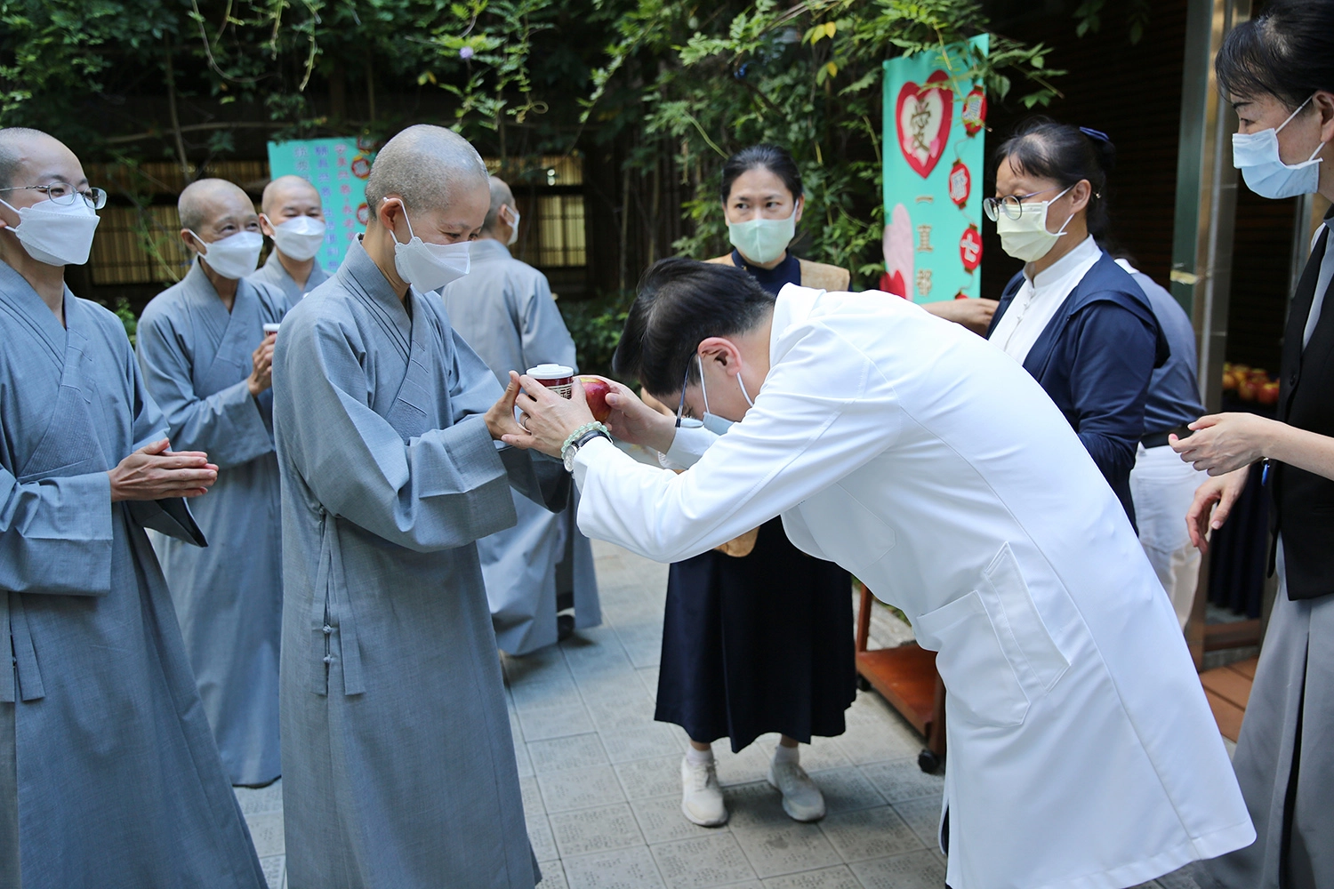 林欣榮院長於會後發送福慧粥、蘋果與會眾結緣，特別感恩精舍師父帶領祈福會。(江家瑜攝)