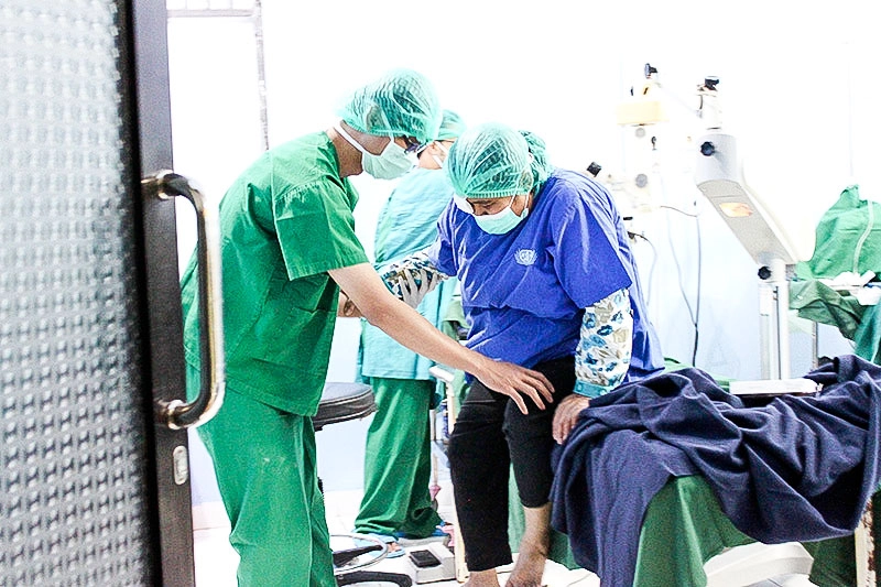 六月二十四至二十五日舉行的義診和手術上，醫療人員小心攙扶完成手術的眼疾病人起身。