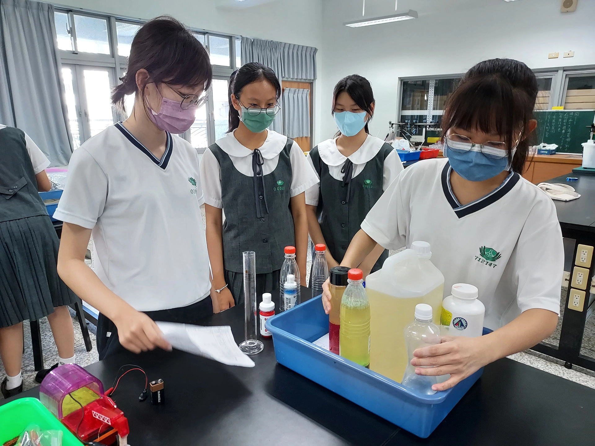 高二數理實驗班蔡頎頤、徐湘縈同學，正在指導國二學生如何製作熔岩燈。