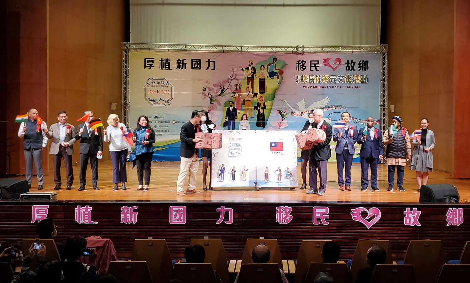 移民署署長鐘景琨（左六）與桃園市副市長李憲明(右五)，分別於魔法書上蓋下象徵中華民國入境查驗章及國旗，揭開移民節活動序幕。