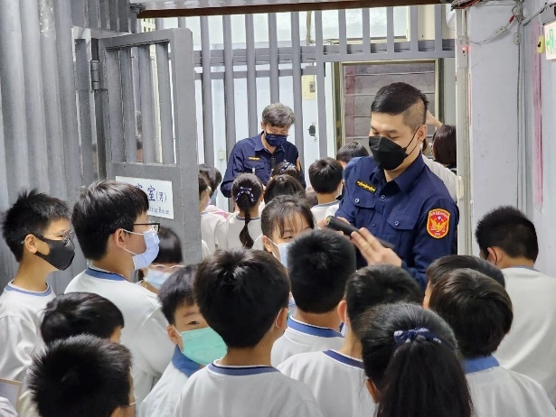 參觀法院時，法警向學生介紹隨身裝備