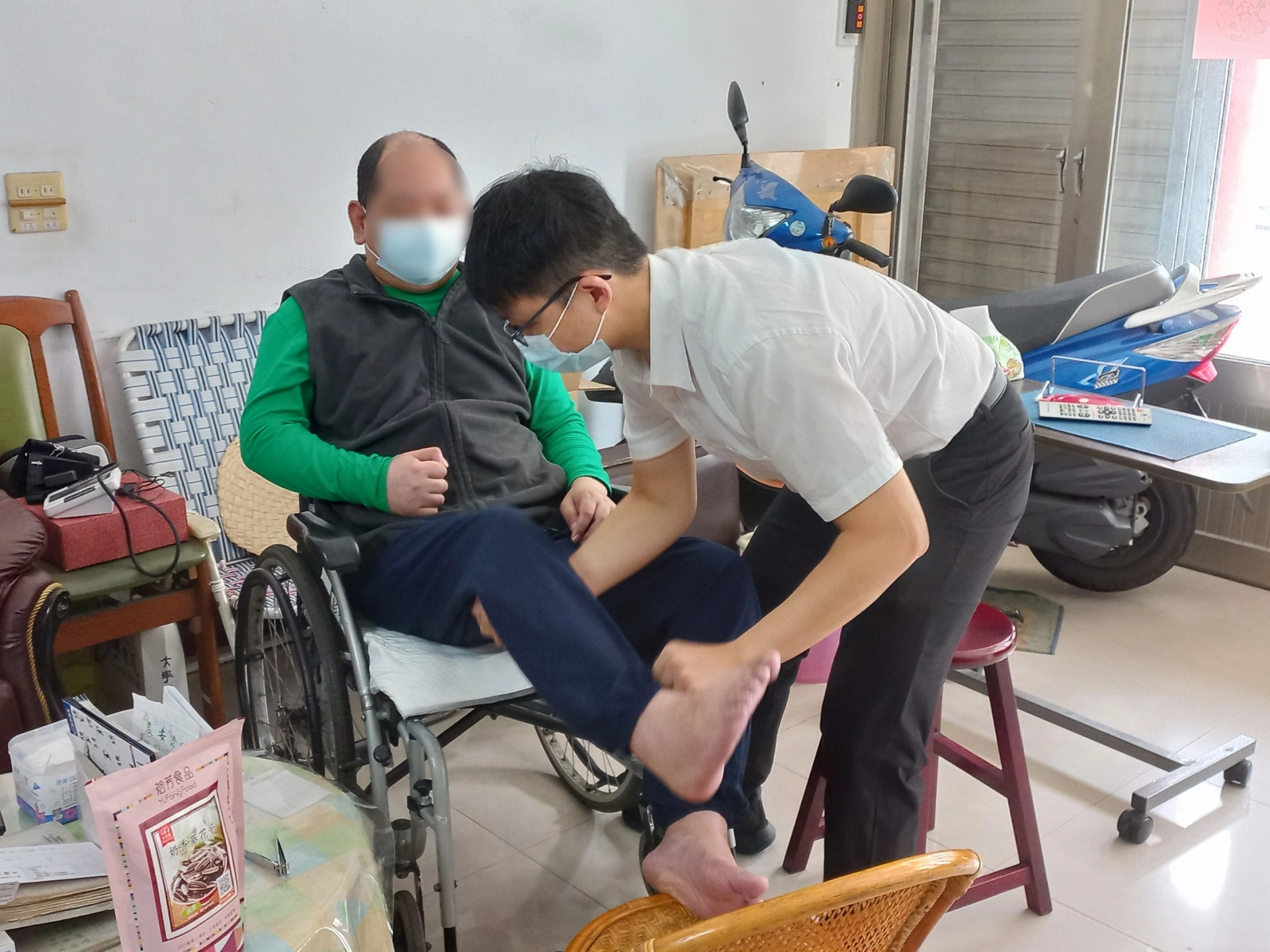 周仁傑醫師（右）關心中風鄉親肢體狀況。