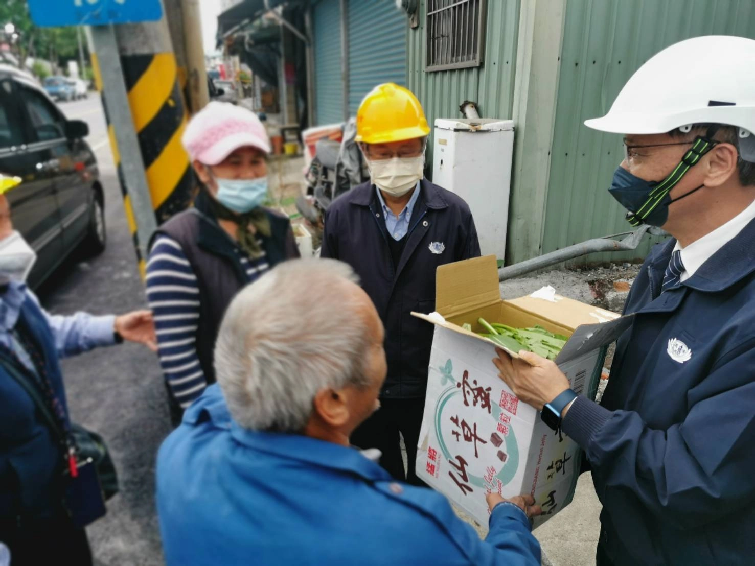 張女士在冬至這天聽聞慈濟要來了解重建進度，親手摘了一箱油菜請鄰居幫忙送給慈濟。(攝影：陳祖淞)