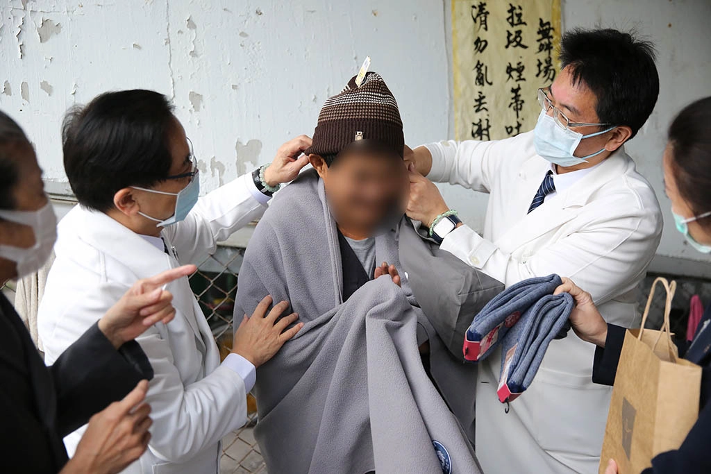 花蓮慈院林欣榮院長與團隊拿出準備好的毛毯、毛帽等為李先生圍上，並送上保暖的襪子，希望在這寒冷的天氣裡，為他增添一些暖意。