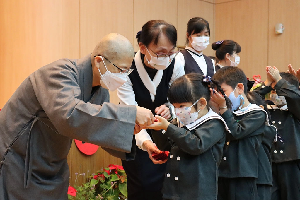 幼兒園的孩子恭敬地上台領取師父的福慧紅包。