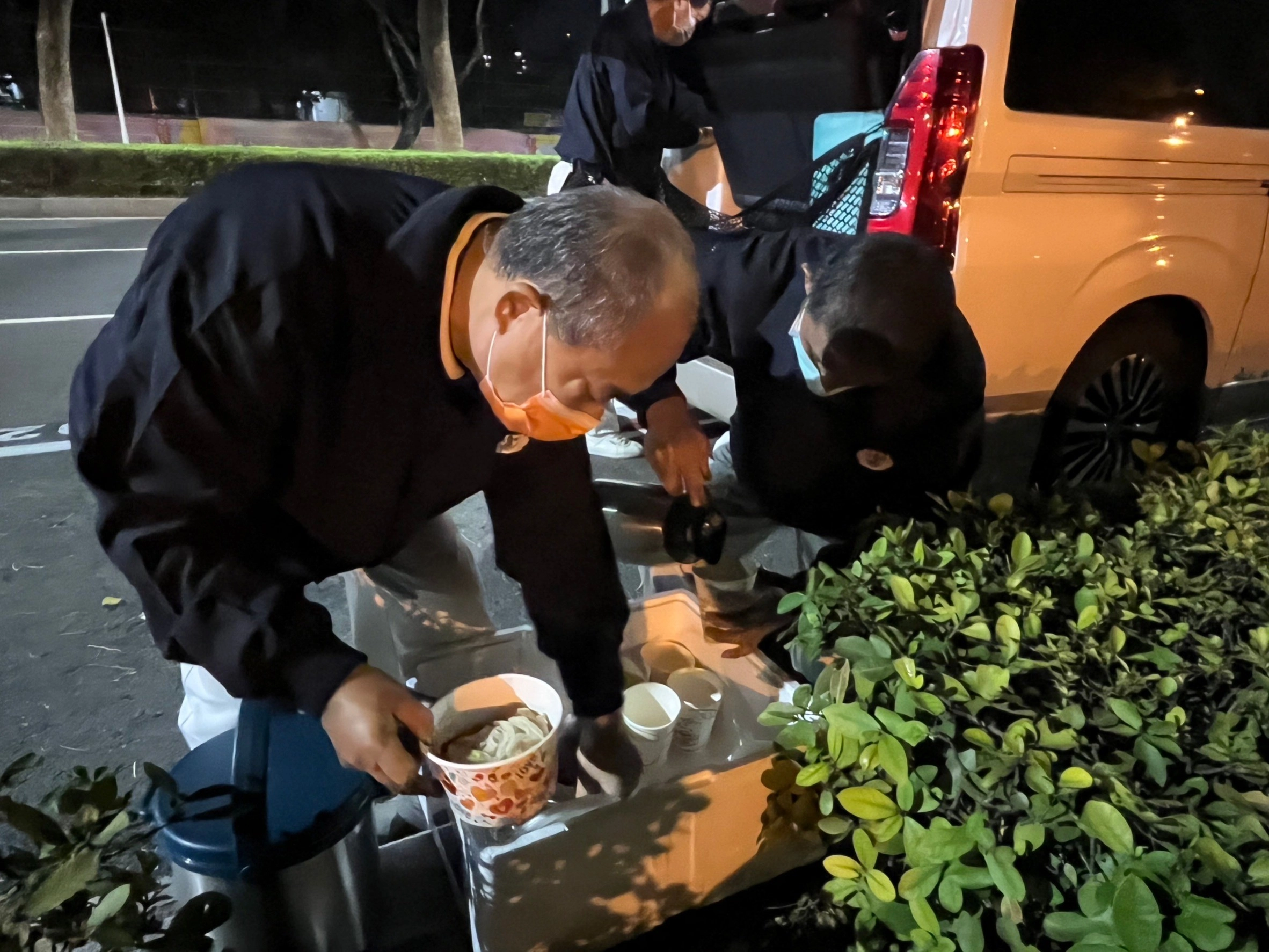 到達關懷定點後，慈濟志工將熱熱的藥膳補湯裝進碗中並分送給街友。