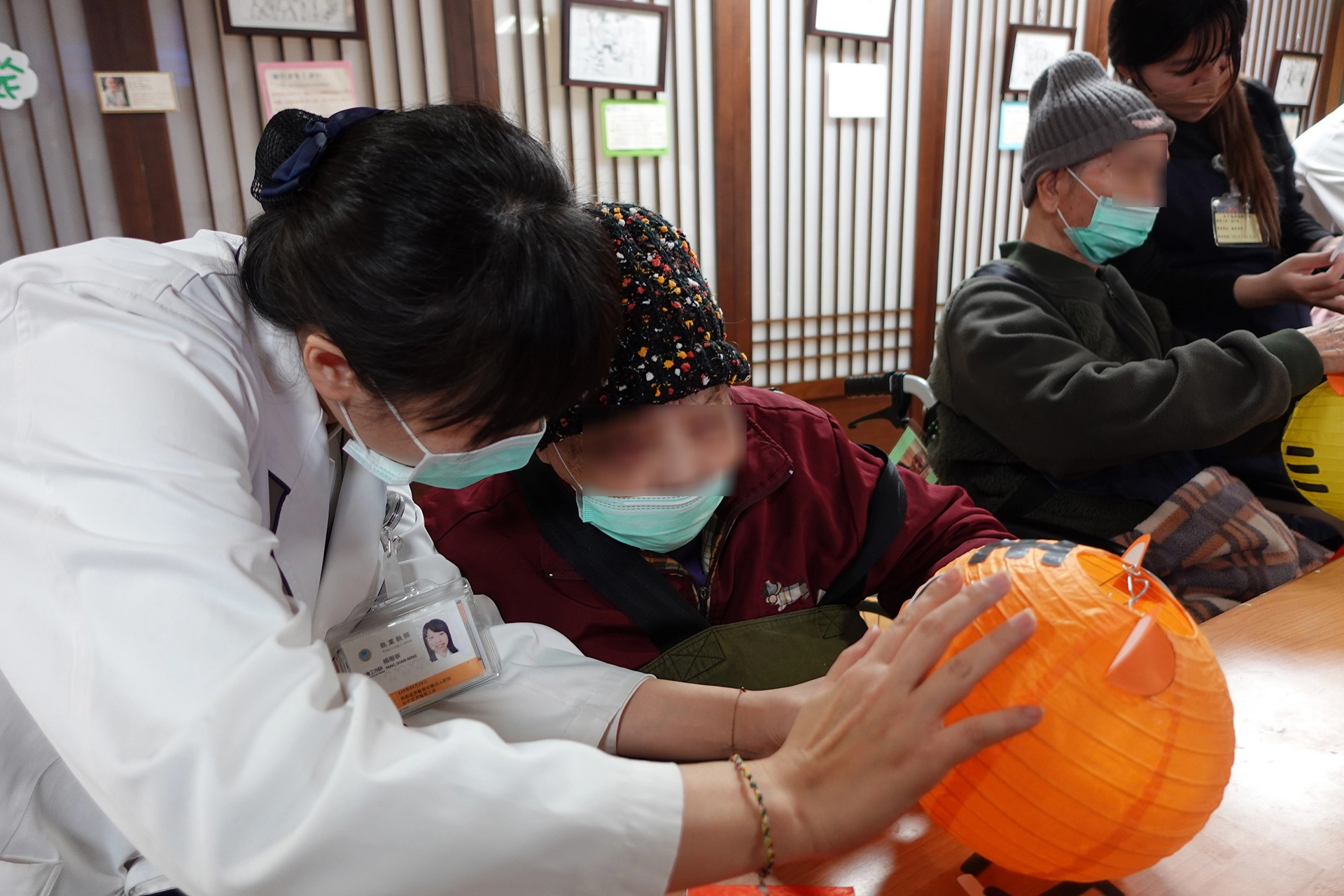 楊珊寧社工師正在和住民奶奶討論老虎五官的擺位。