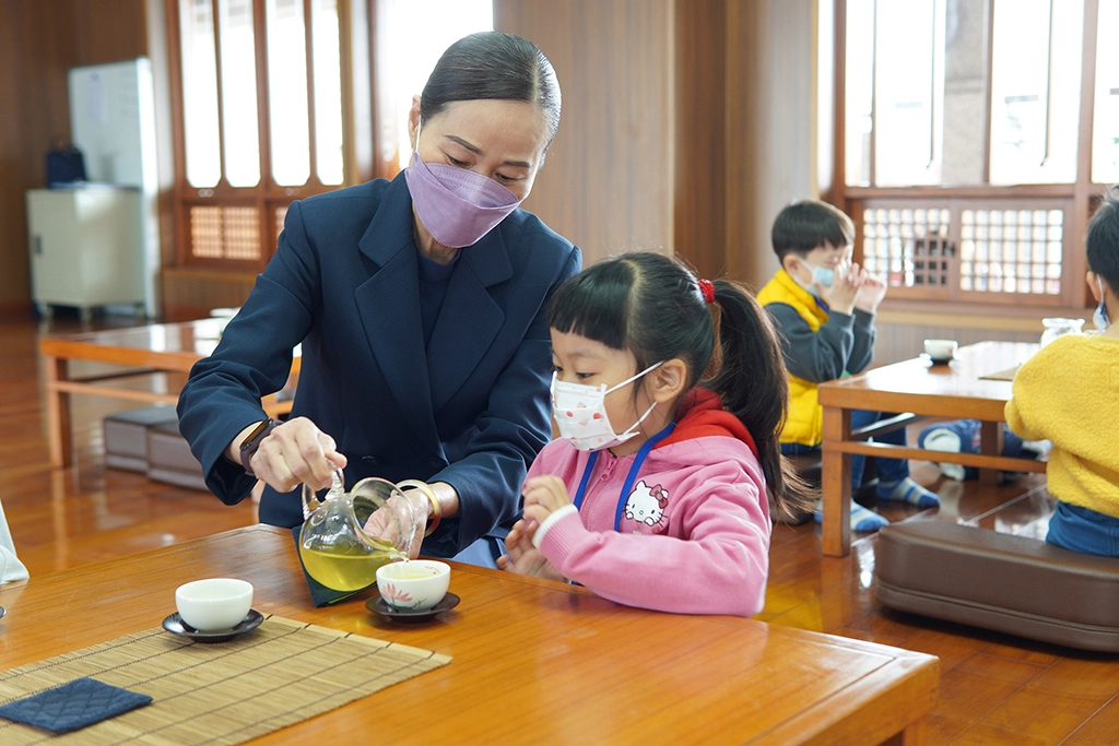 茶道老師示範如何倒茶，學習當個小主人。