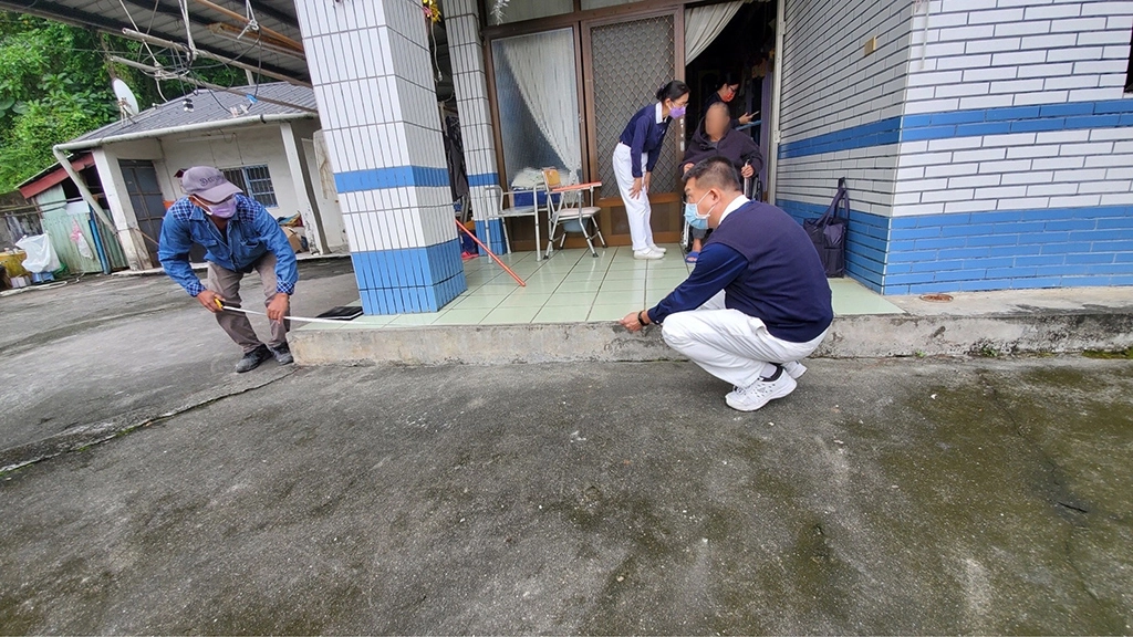 慈濟為案家規劃無障礙坡道與扶手、防雨設施、屋外照明設備加強等修繕工作，圖為過年前與工程人員確認修繕內容。