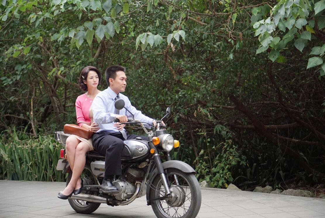 丁炎載著吳招騎著車上班