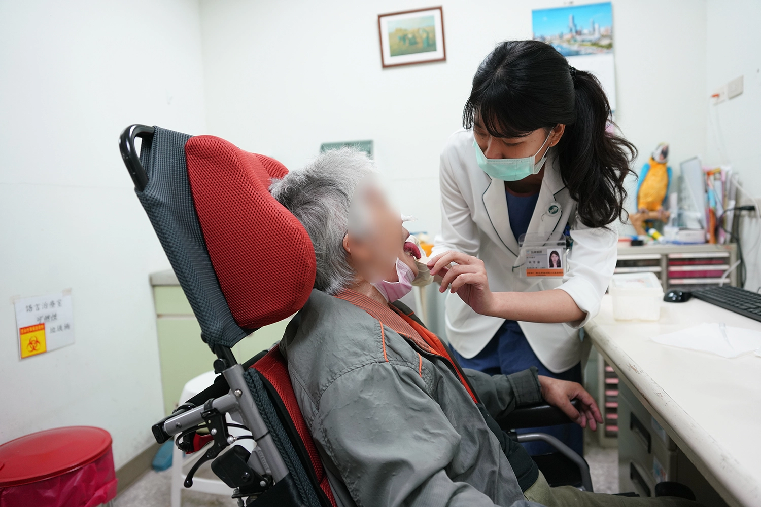 語言治療師林佳瑜利用壓舌板引導病人做舌頭抗阻力運動，訓練其舌頭上抬之肌肉力量。