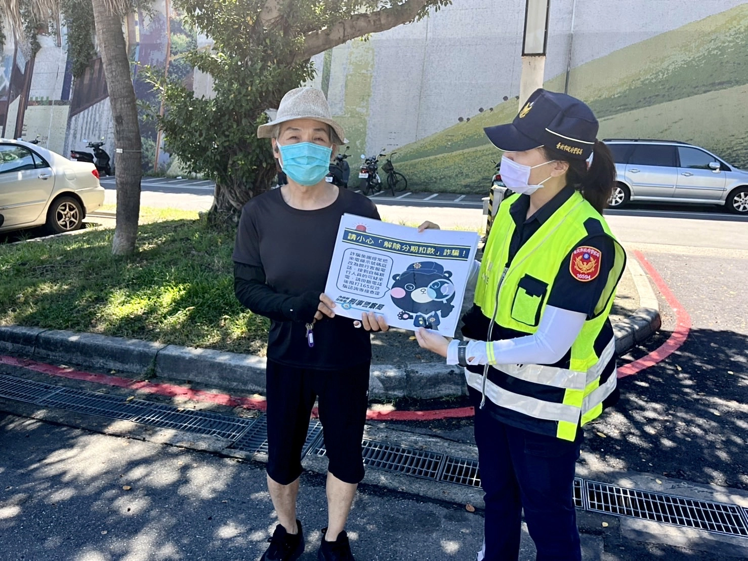 保大警手持宣傳標語，提醒民眾常見的網路詐騙手法。
