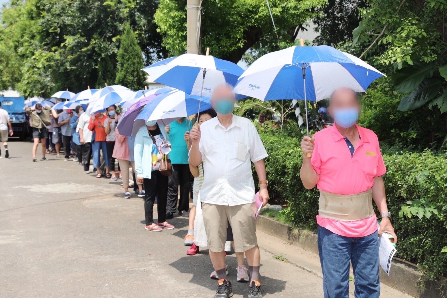 臺中慈濟沙鹿聯絡處貼心的提供陽傘，讓長者在排隊等候疫苗施打時免受曝曬之苦。